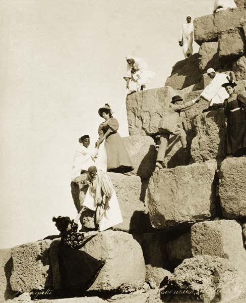 Tourists ascending the pyramids with native guides (b/w photo)  de English Photographer