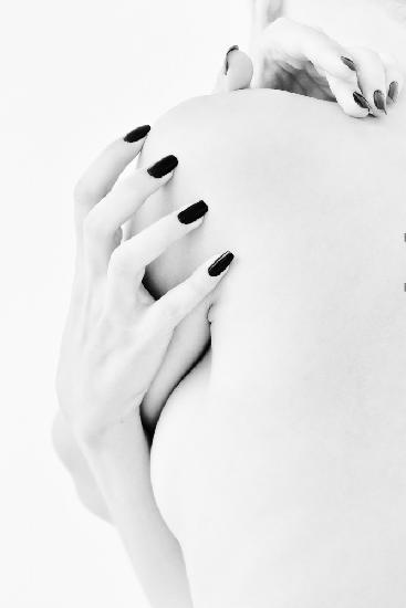 body parts of a naked girl torso and hand pressing her breasts with a black manicure on her nails