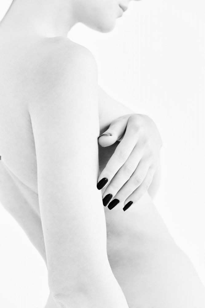 body parts of a naked girl torso and hand pressing her breasts with a black manicure on her nails de Alexandr