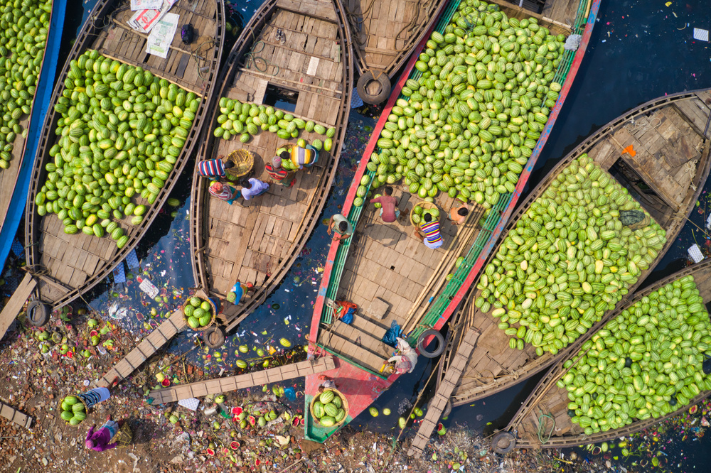 Workers unload watermelons from the boats using big baskets de Azim Khan Ronnie