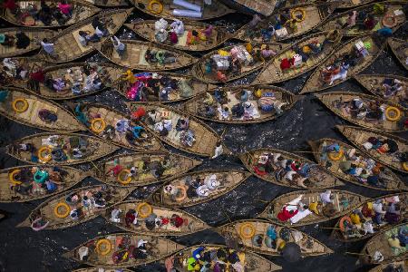 Boats filled with travelers crossing the river to their workplace