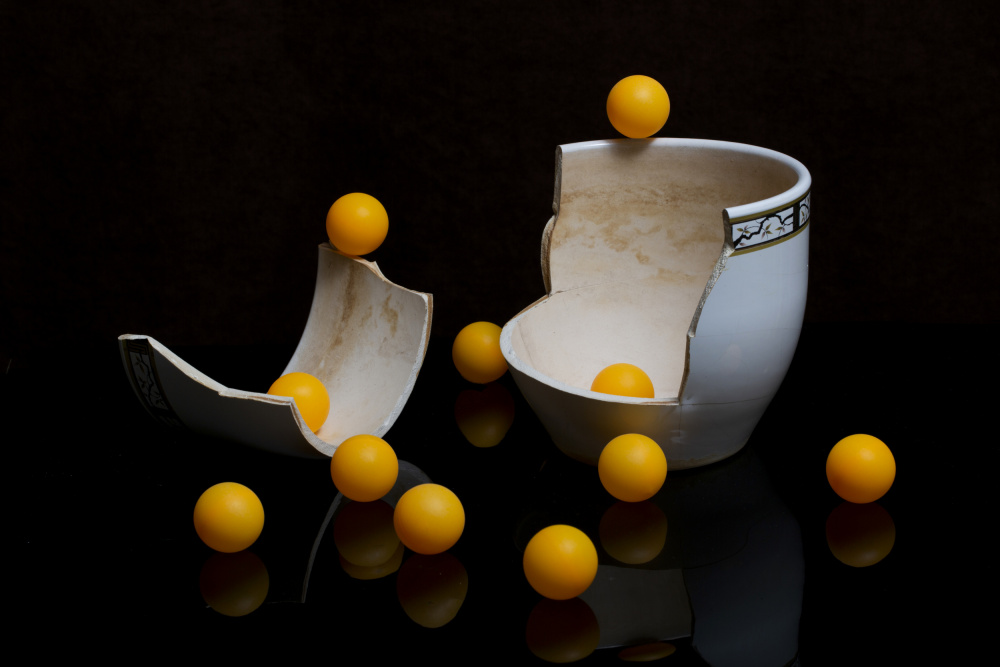 A broken vase with orange balls de Brig Barkow