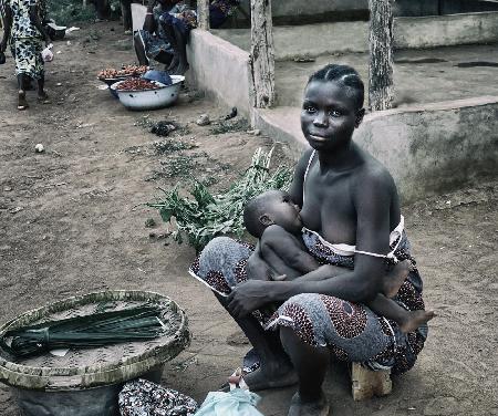 Breastfeeding her child in the market (Benin)