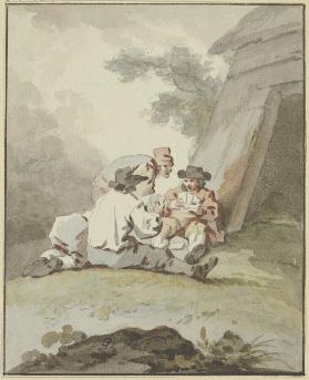 Vier Männer vor einer Hütte am Boden sitzend oder hockend beim Kartenspiel