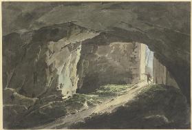 Ein Maler läuft mit seinem Zeichenbrett in eine mit einem gewaltigen Tor verschließbare Felshöhle