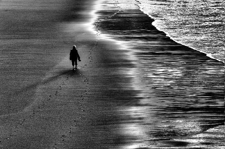 Between sand and water, lonely woman