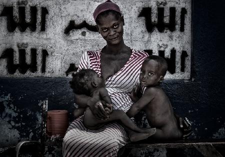 Breastfeeding her children in the streets of Acrra - Ghana