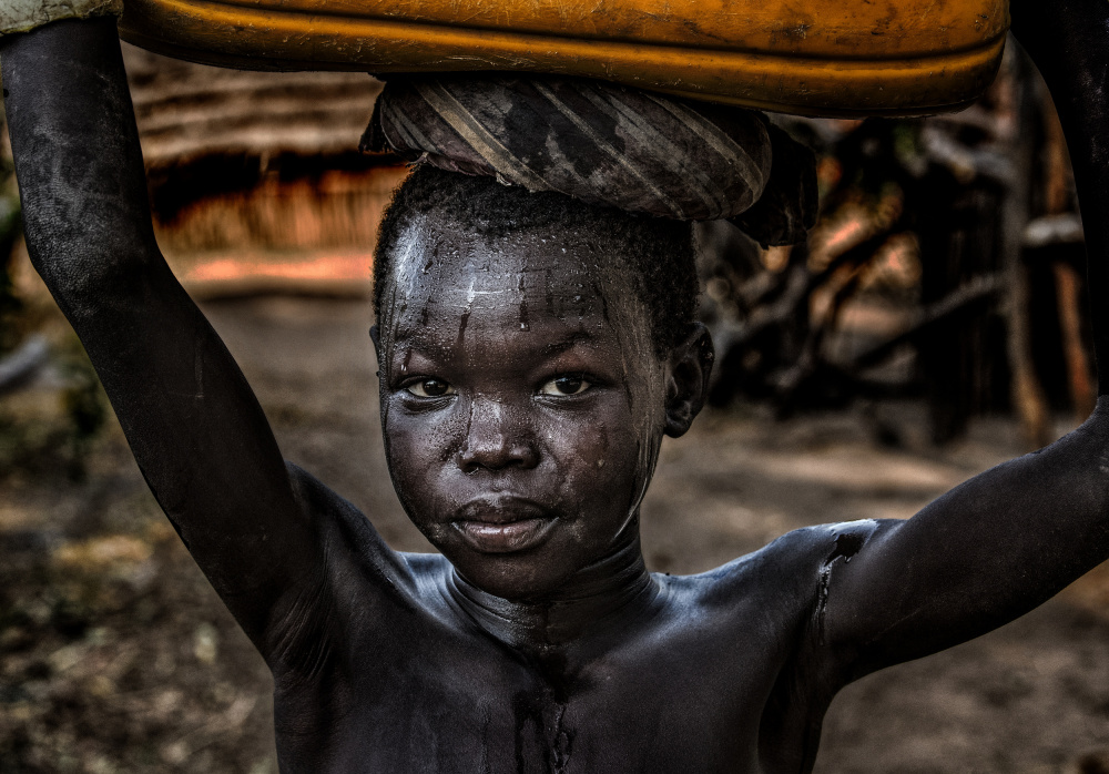 South sudanian child carrying a water containera de Joxe Inazio Kuesta Garmendia