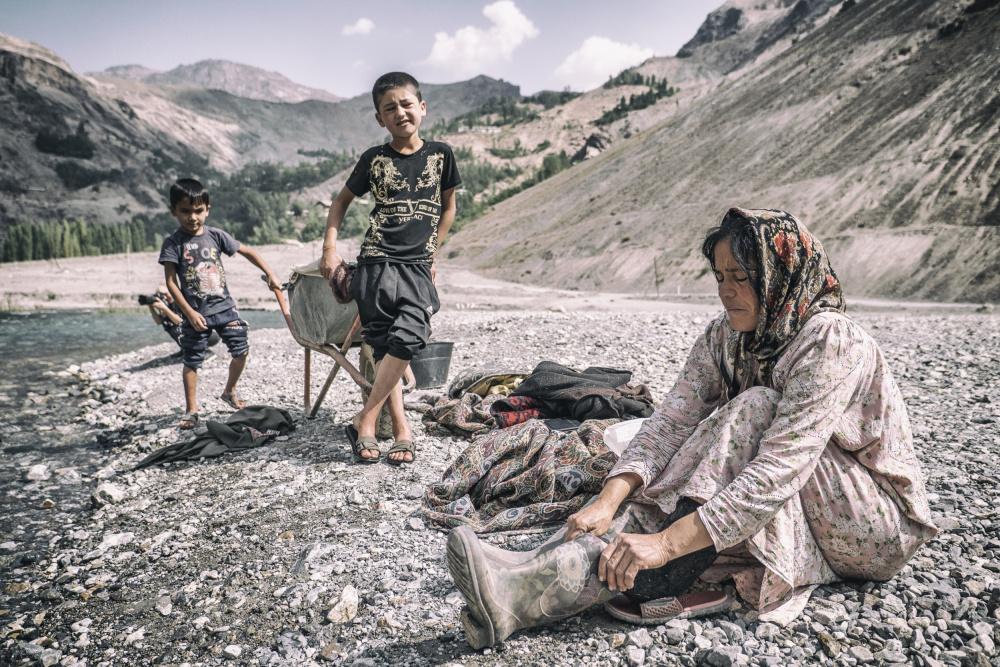 A Tajik woman is preparing to wash in the stream de Marcel Rebro