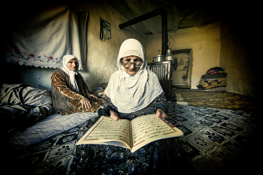 The old woman is reading the Koran. de Mehmet Çetin