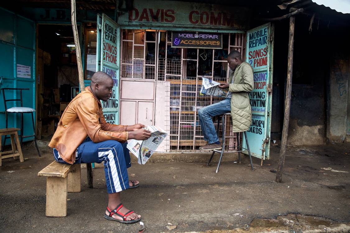Zeitung am Kiosk in Nairobi, Kenia, Portrait Mann Kenya de Miro May