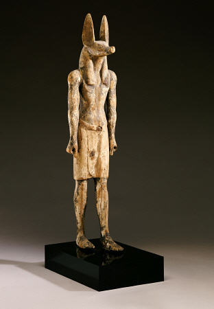 An Egyptian Wood Figure Of A Jackal-Headed Deity de 
