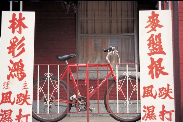 Bicycle at metal bars with Chinese board , Singapore (photo)  de 