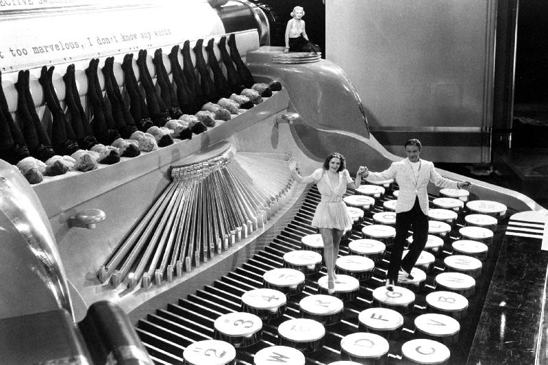 Couple dancing on the key of a giant typewriter, keys are leg of dancers, musical de 