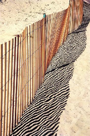 Reflejo de la valla en la arena