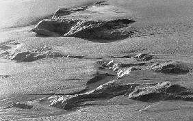 Rock on wet sand (b/w photo) 