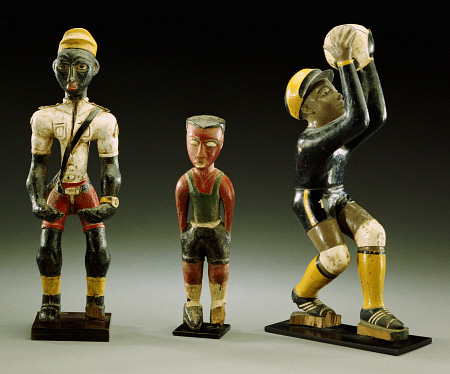 Three Male Carved Figures, One Wearing An Official''s Uniform, The Other Two In Sports Gear de 