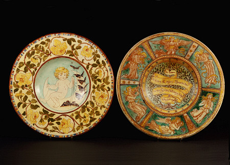 Two Della Robbia Wall Chargers, One Depicting A Putto Riding A Crescent Moon, The Other Designed By de 