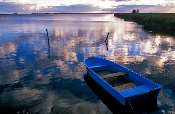 Blaues Boot am Seeufer mit Wolkenstimmung de Robert Kalb