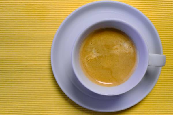 Kaffeetasse mit Kaffee auf gelbem Untergrund de Robert Kalb