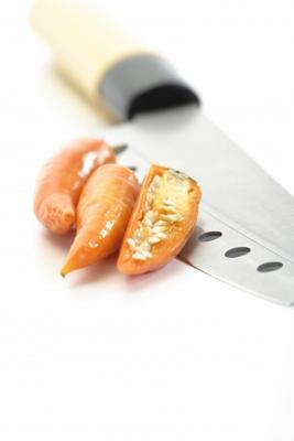 Gelbe Peperoni mit Messer de Thomas Haupt