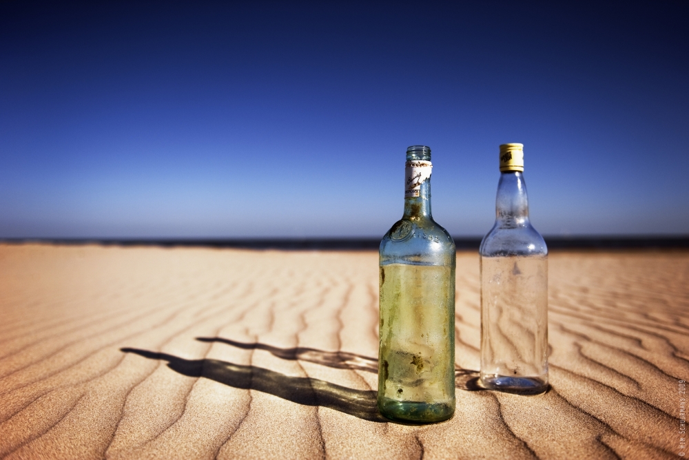 Bottles on sand de Wim Schuurmans